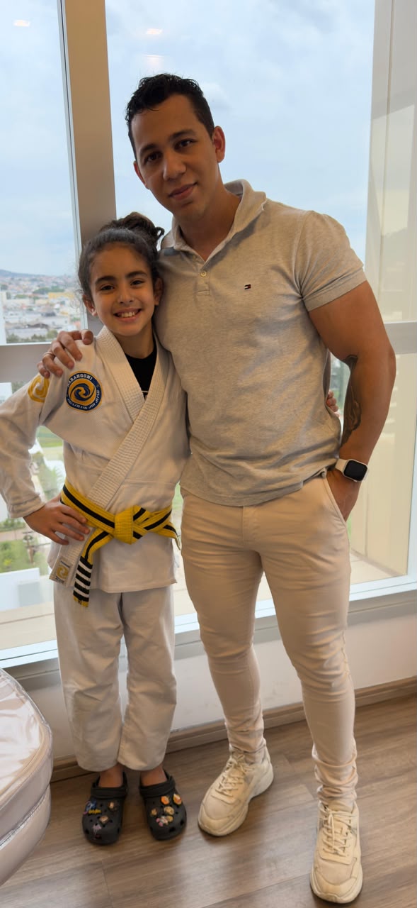 Jonathan Rodrigues ao lado de uma criança atleta de jiu-jitsu